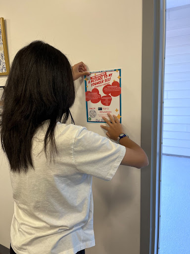 Katherine Bui puts up a poster for Club Elevated