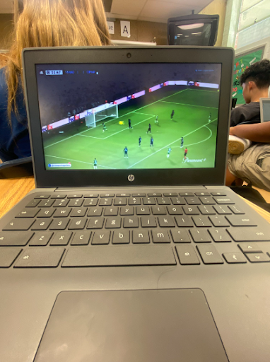 A student watching a Champions League group stage match between PSG and Real Madrid in class