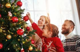 Smiling family decorates Christmas Tree (iStock images)